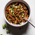 Prepared gyoza dipping sauce in bowl with spoon.