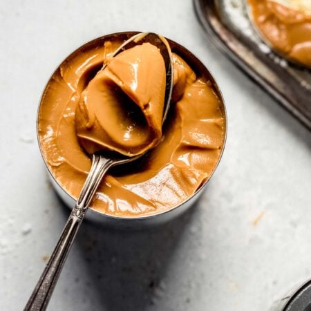 Spoonful taken out of can of dulce de leche made with condensed milk.