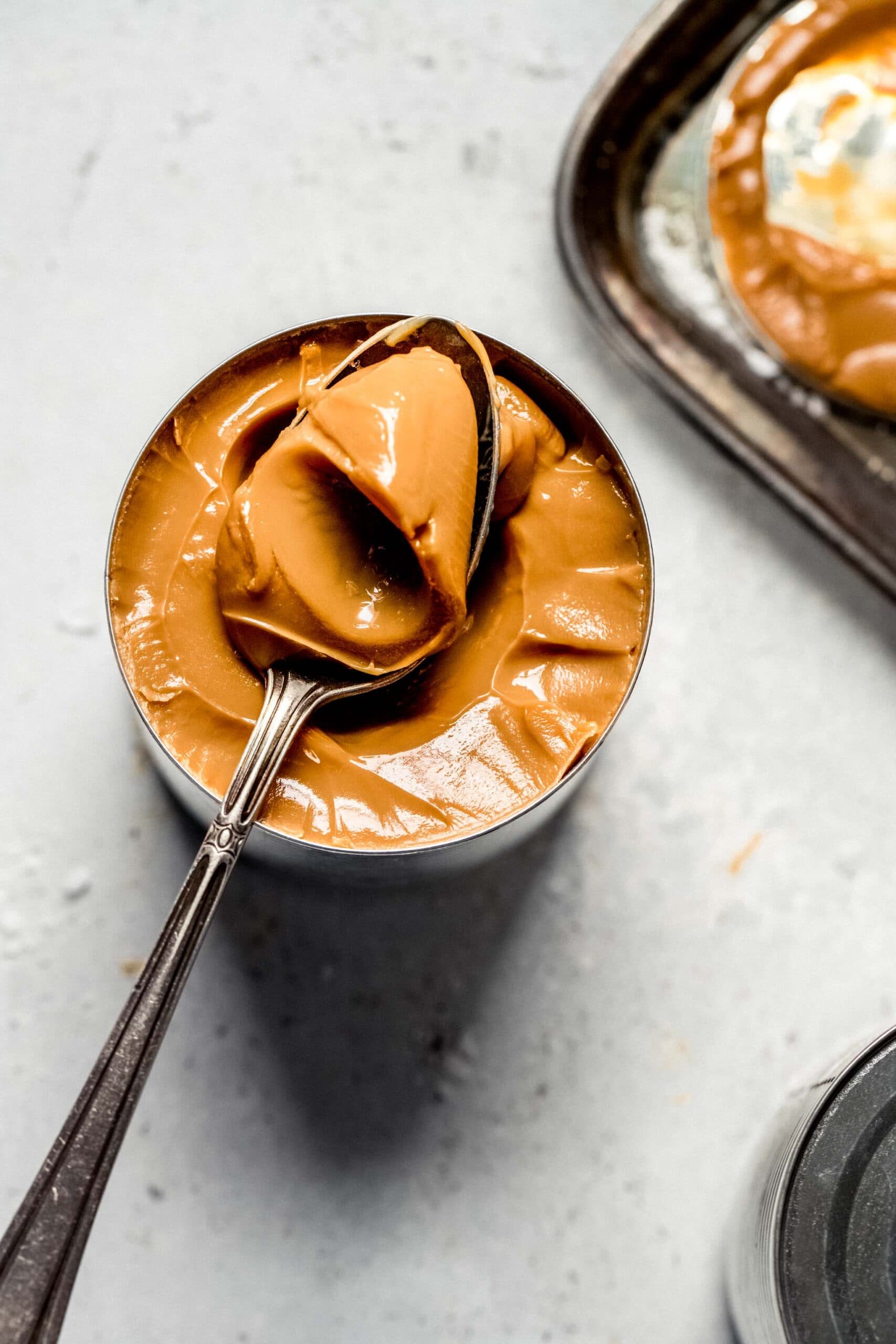 Spoonful taken out of can of dulce de leche made with condensed milk.