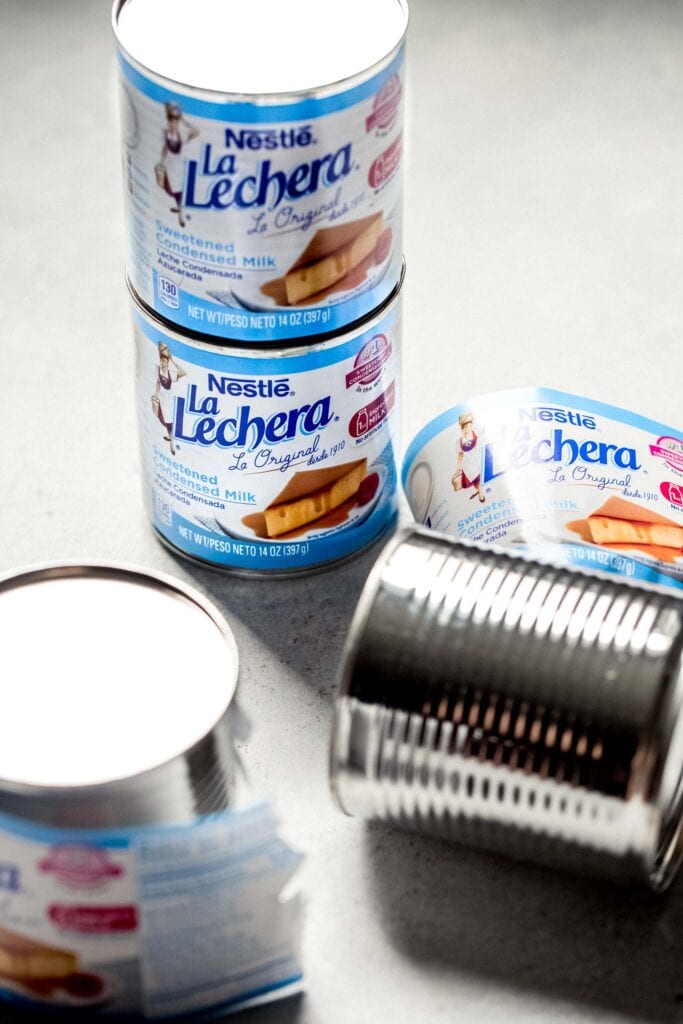 Cans on condensed milk on counter. 