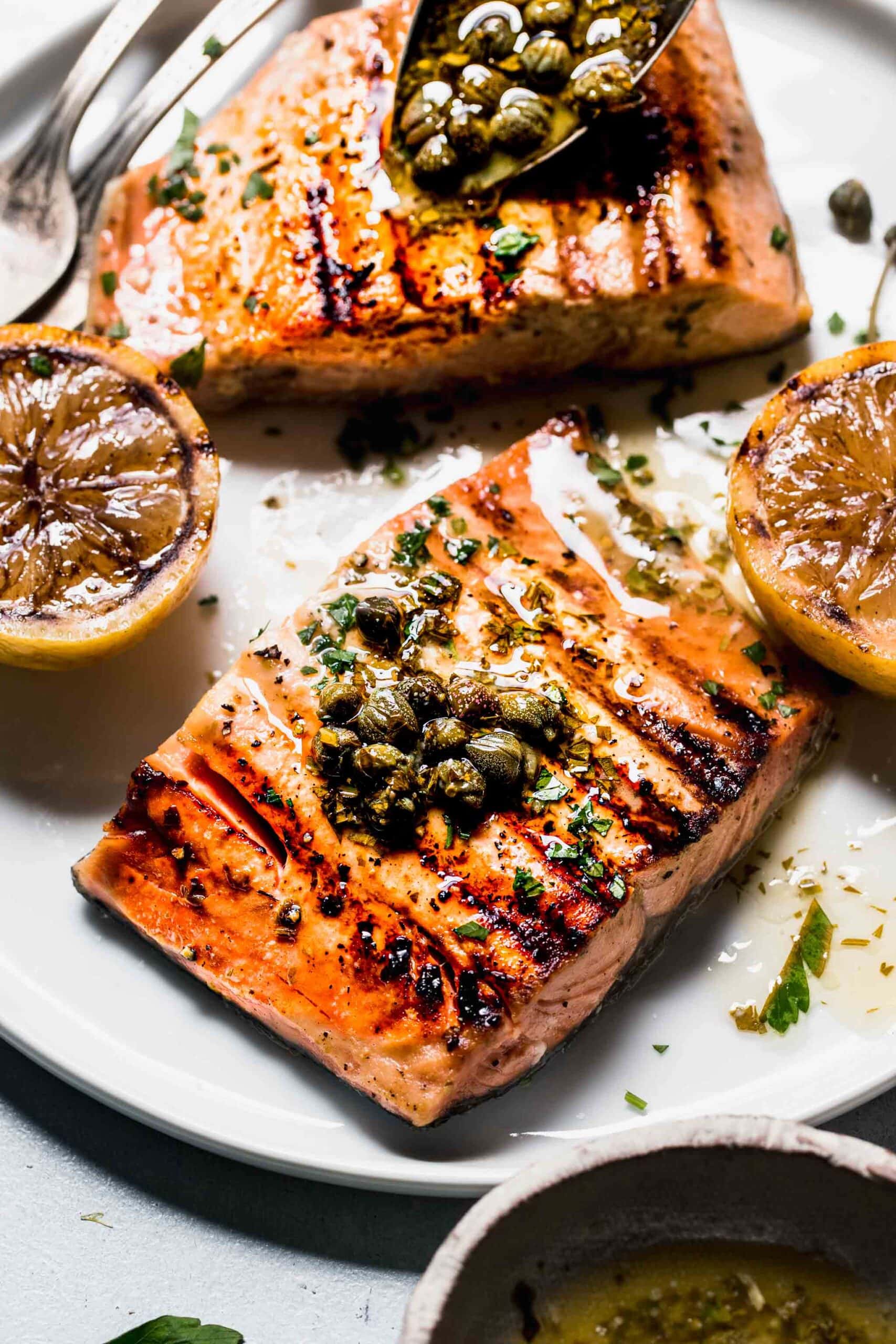 Close up of prepared salmon with sauce on plate.