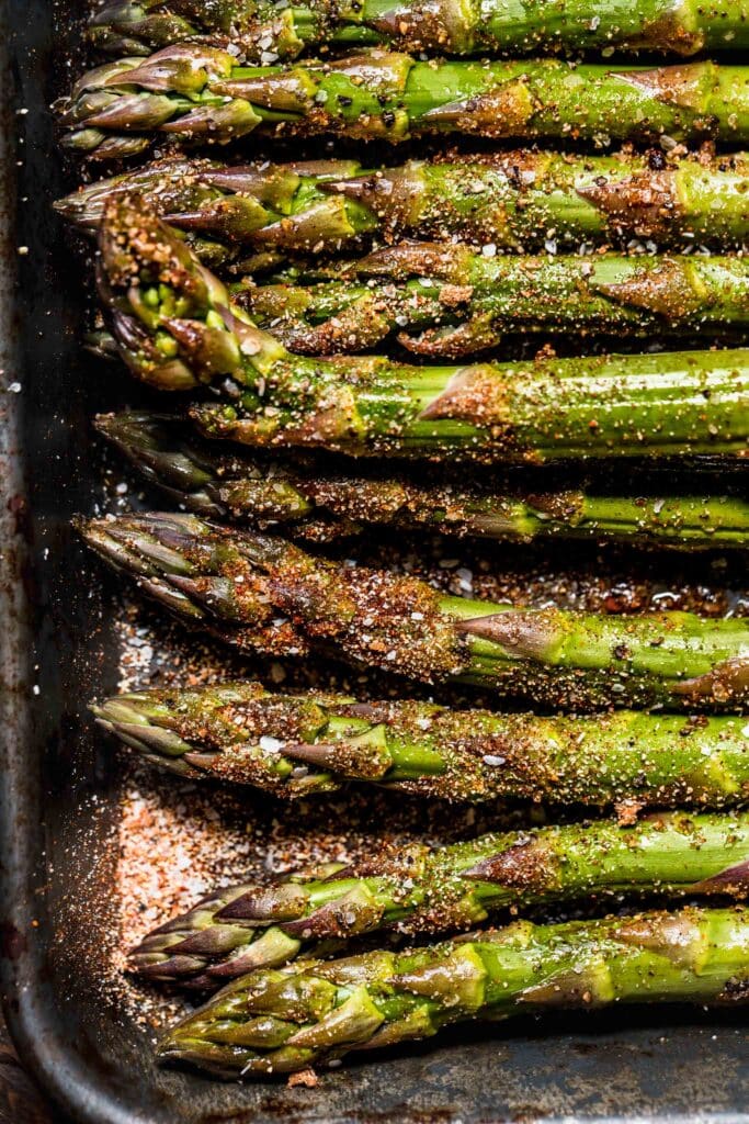 Uncooked asparagus sprinkled with dry rub. 