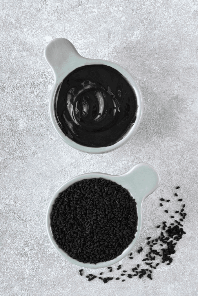 Black sesame paste in small measuring cup. 