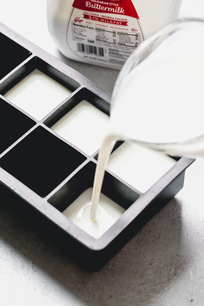 Pouring buttermilk into ice cube tray. 