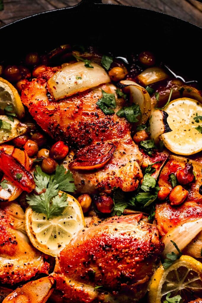Close up of harissa chicken in skillet with chickpeas.