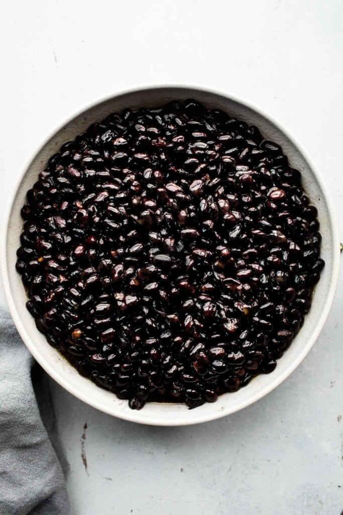 Cooked black beans in white bowl.