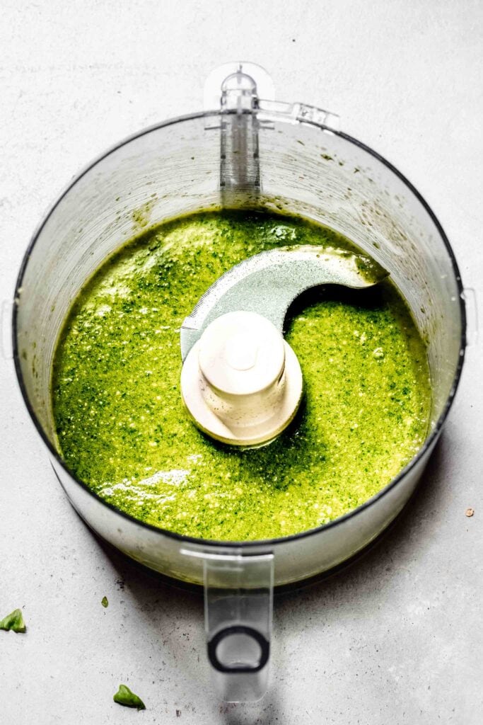 Processed pesto in food processor bowl.