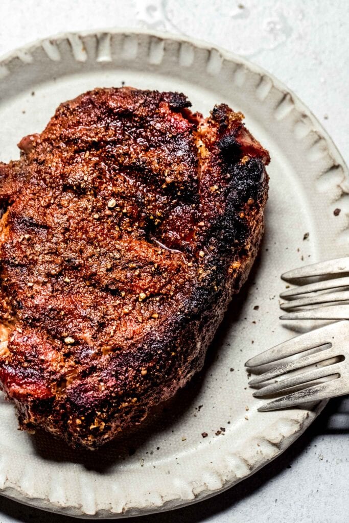 Finished traeger steak resting on plate.