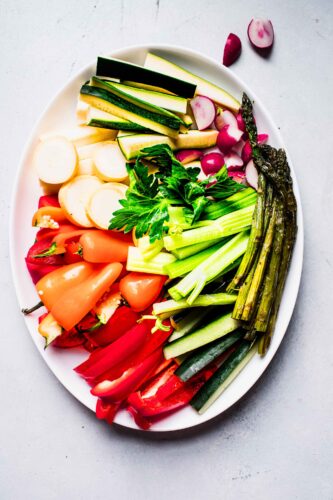Overhead shot of crudité arranged on large white platter.
