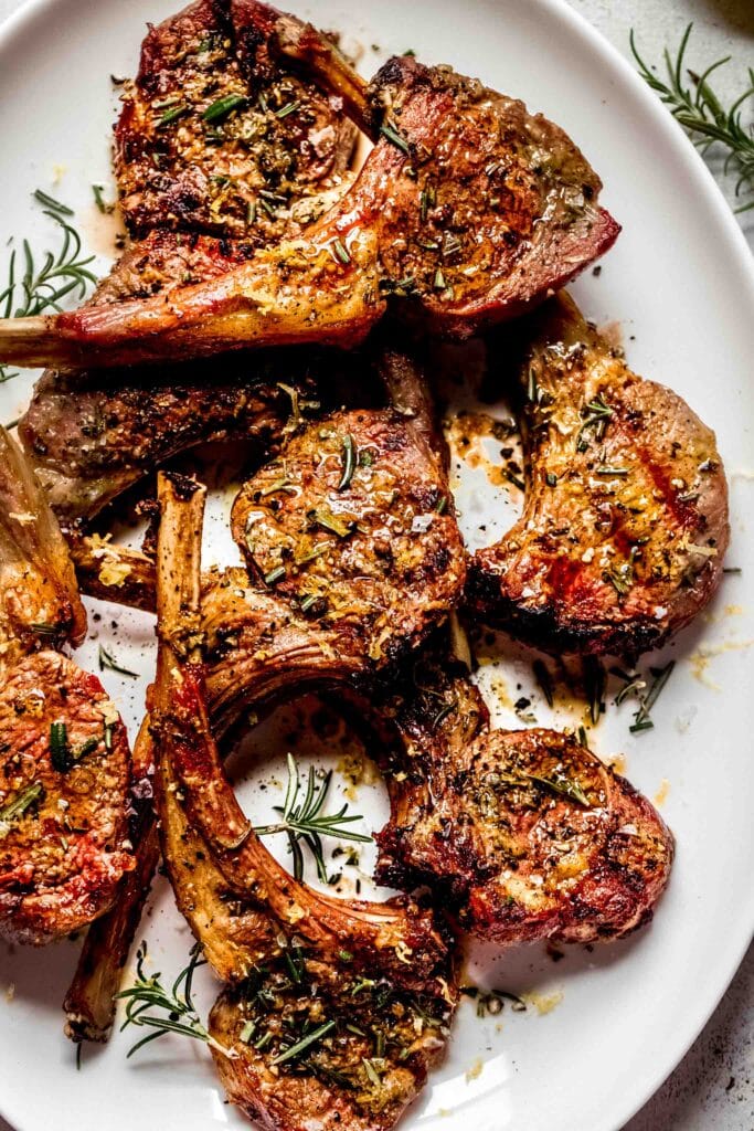 Cooked lamb chops on large white plate. 