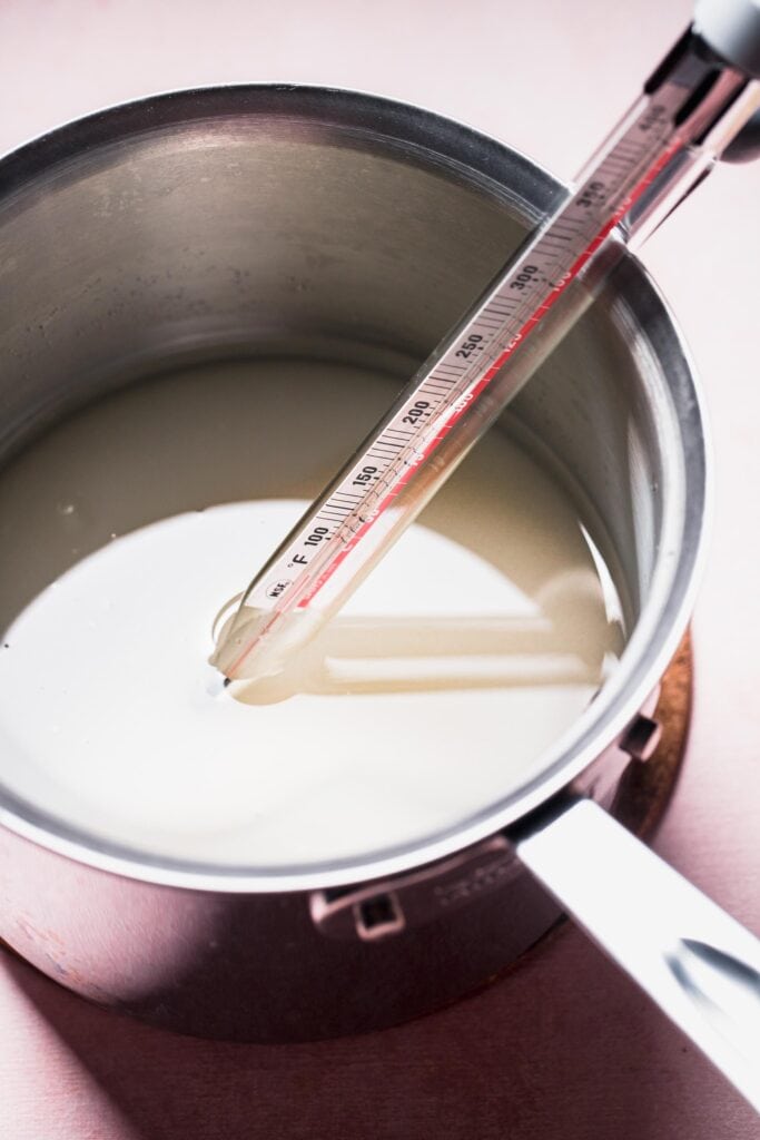 Sugar and water in small pot with thermometer.