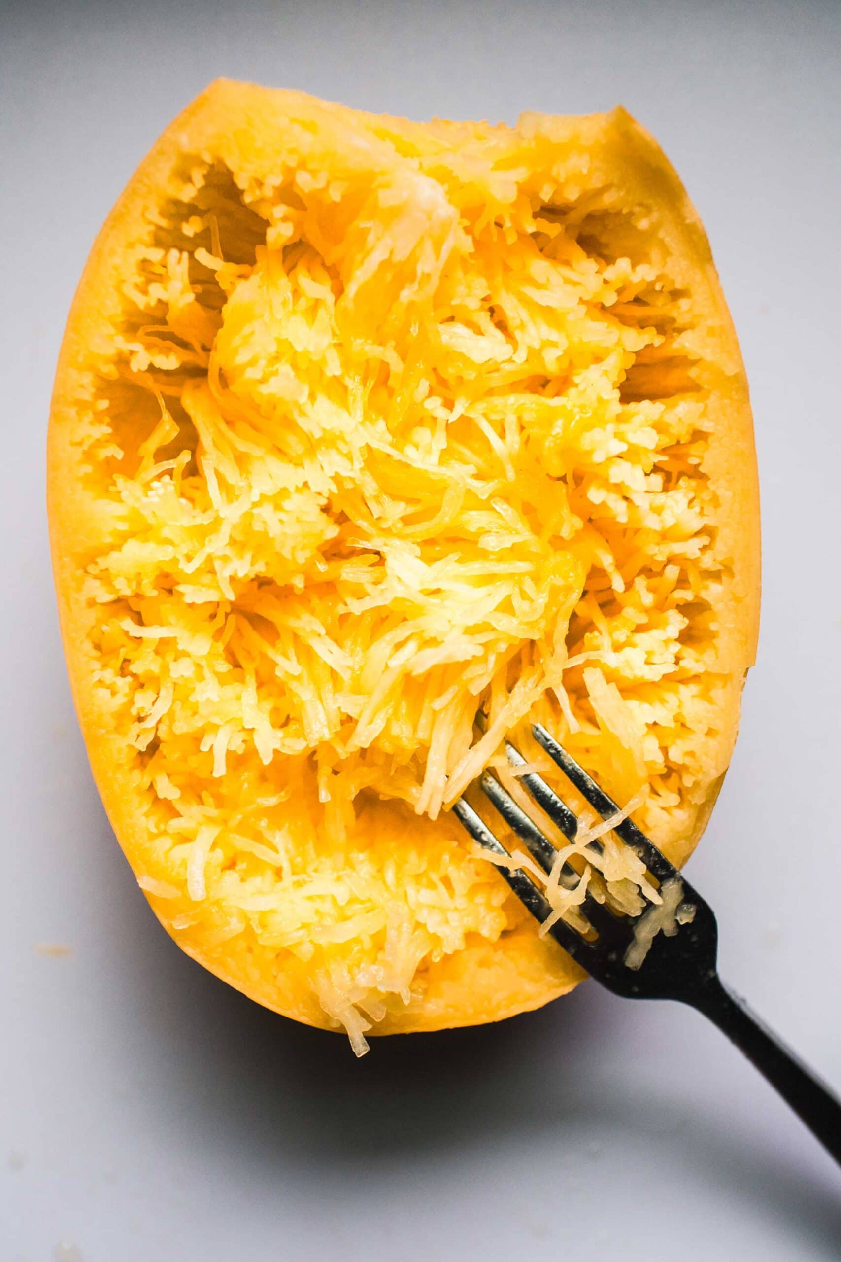 Spaghetti squash being shredded with fork.