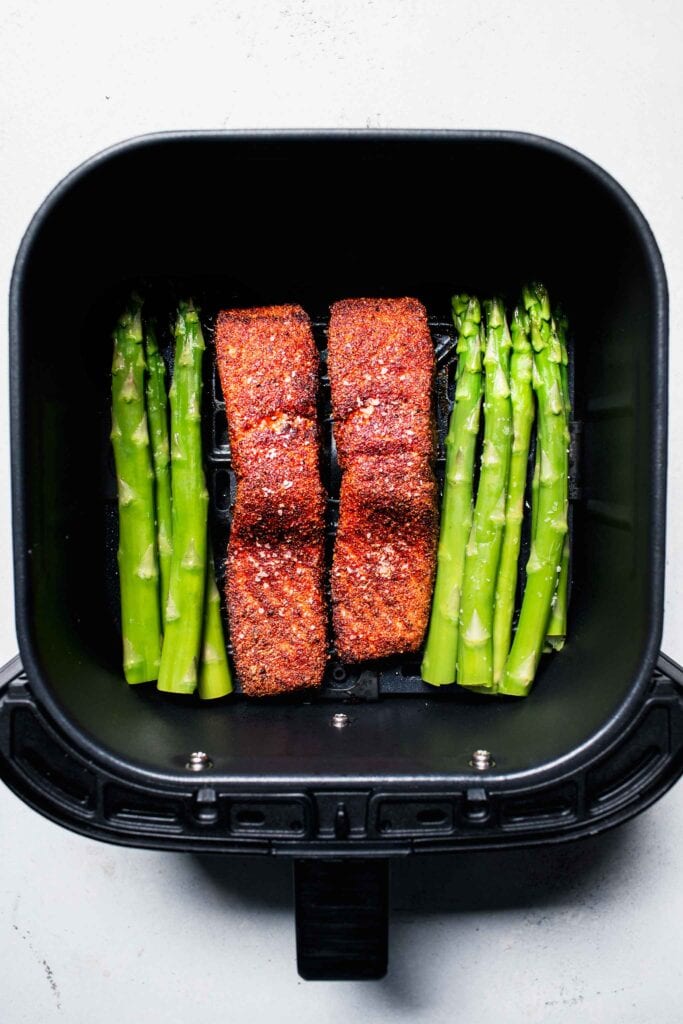 Air fryer salmon and asparagus in basket. 