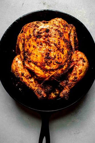 Crispy roast chicken in skillet.