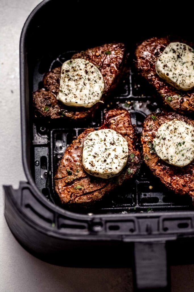 Filets in air fryer basked topped with compound garlic butter. 