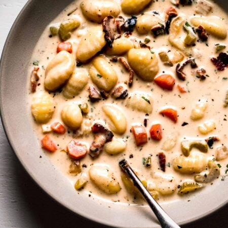 Bowl of creamy gnocchi soup with spoon.