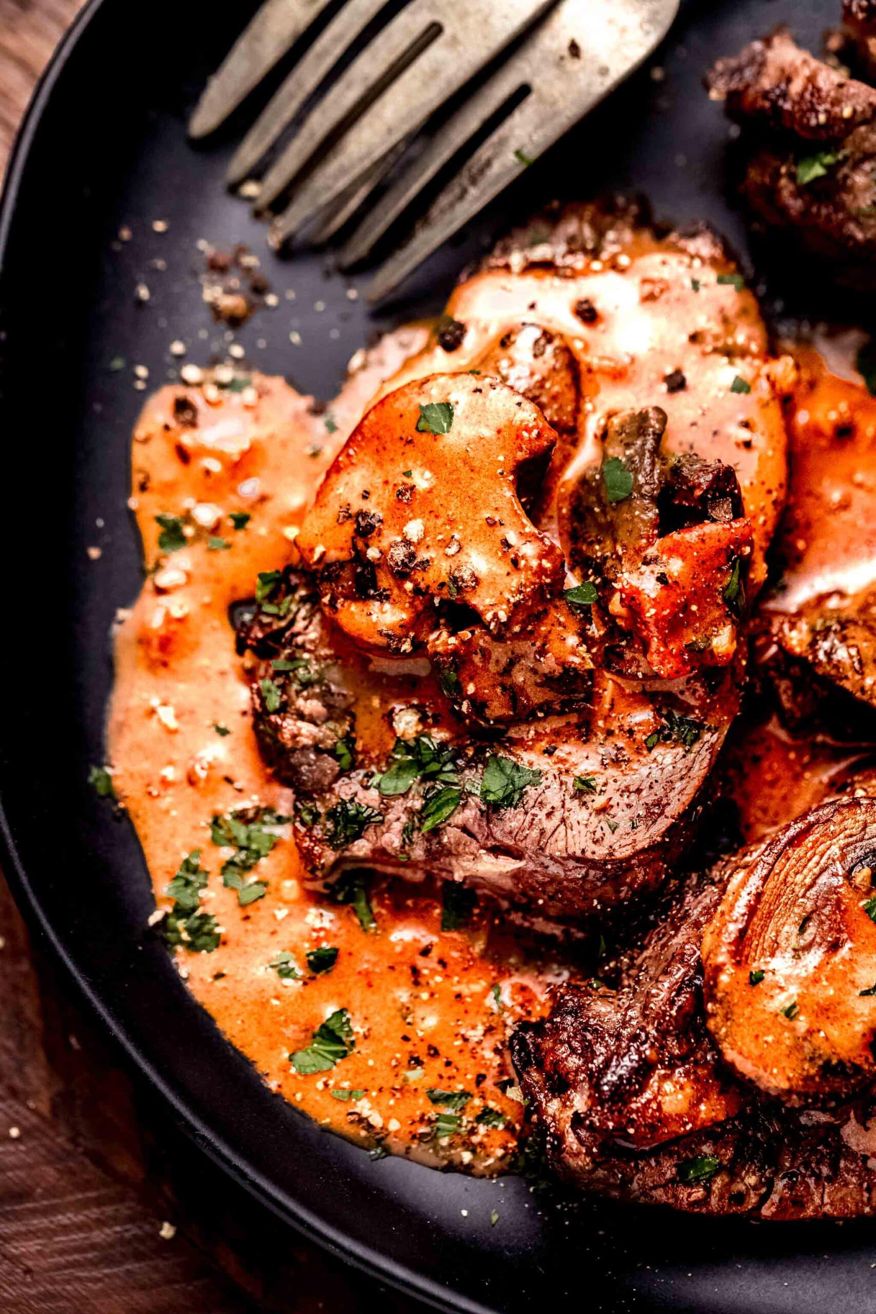 Steak on plate topped with jaeger sauce.