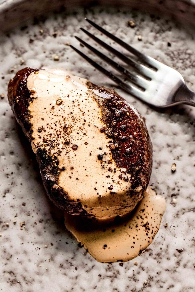 Steak topped with creamy peppercorn sauce.