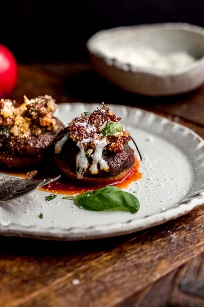 Side view of two stuffed peppers on plate.