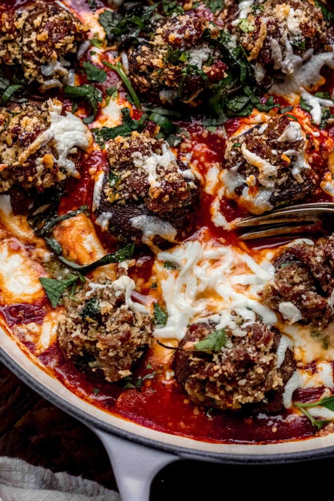 Overhead close up of stuffed mushrooms in skillet.