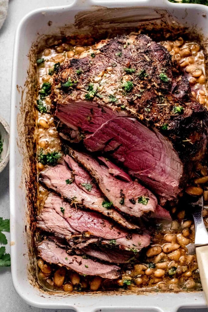 Cooked and carved leg of lamb topped with gremolata. 