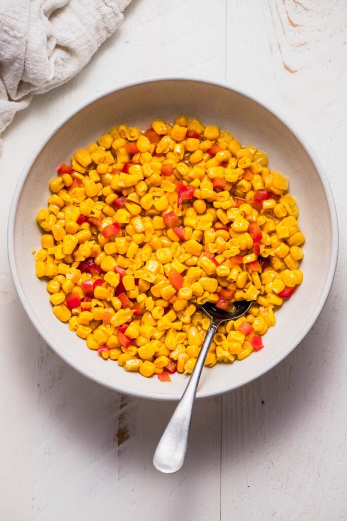 Cooked corn and red peppers in bowl. 