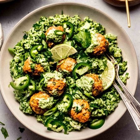 Prepared peruvian chicken meatballs served over green rice and drizzled with aji verde.