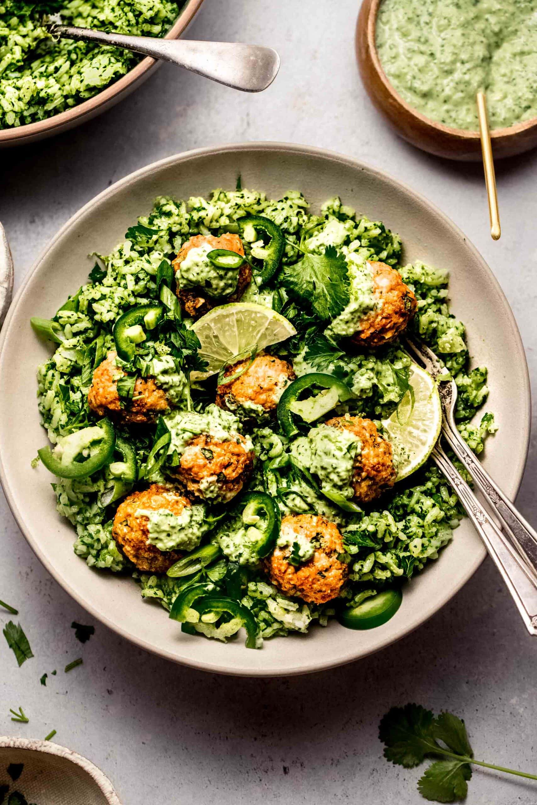 Prepared peruvian chicken meatballs served over green rice and drizzled with aji verde.