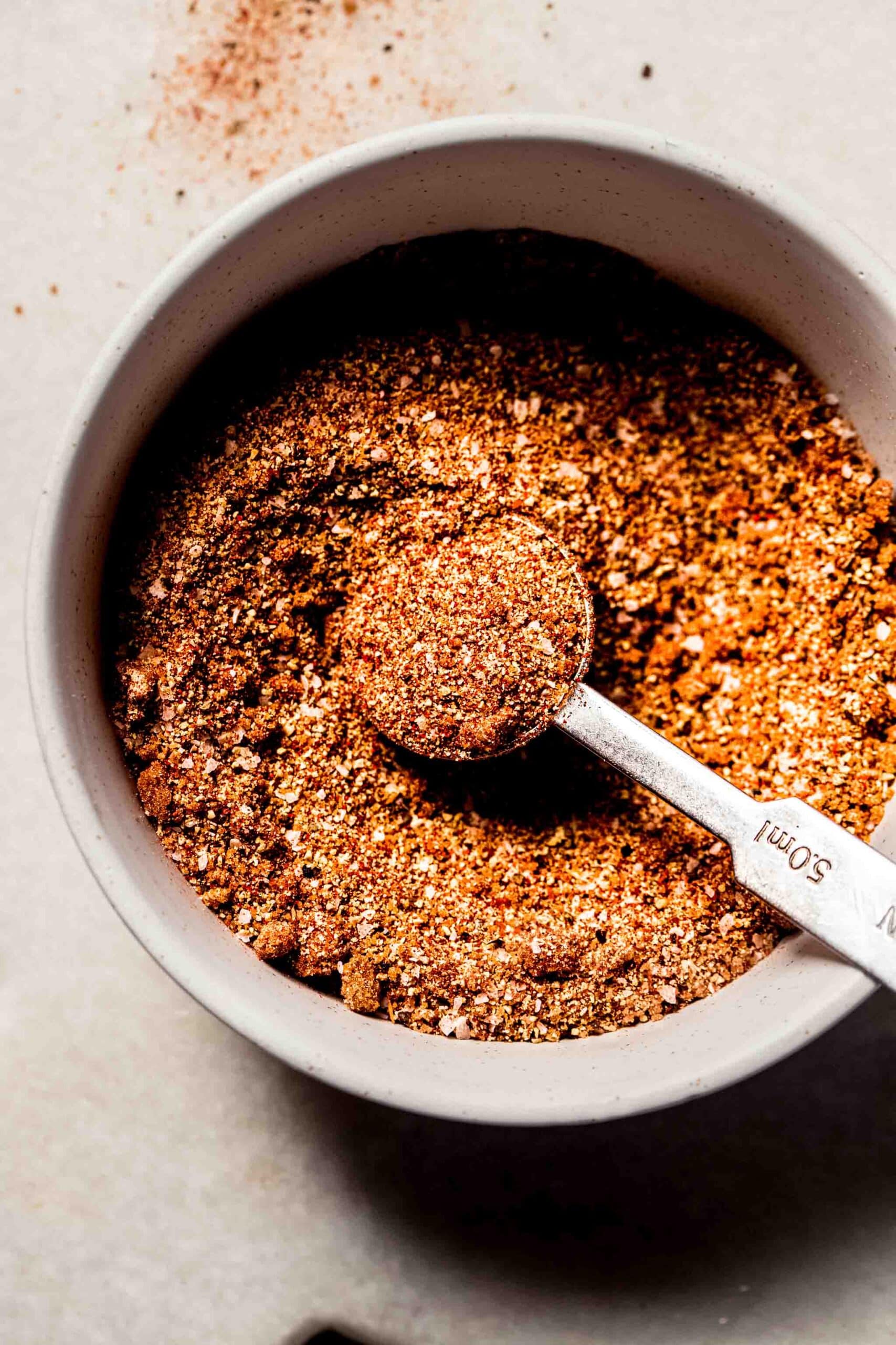 Pork dry rub in small bowl with spoon.