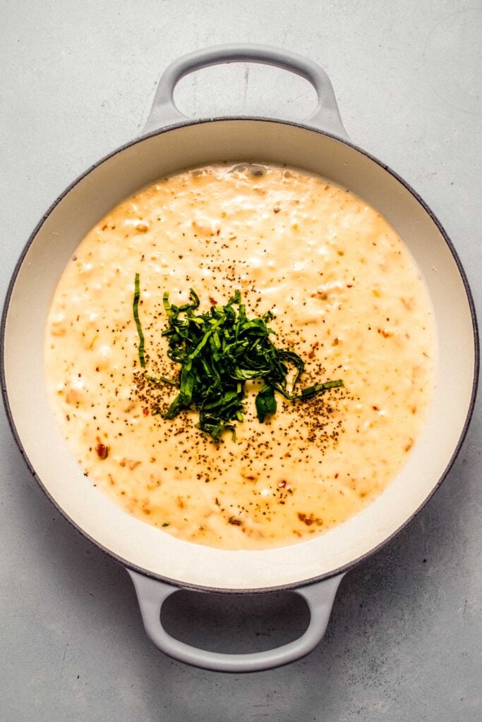 Finished sun dried tomato sauce in skillet topped with julienned basil.