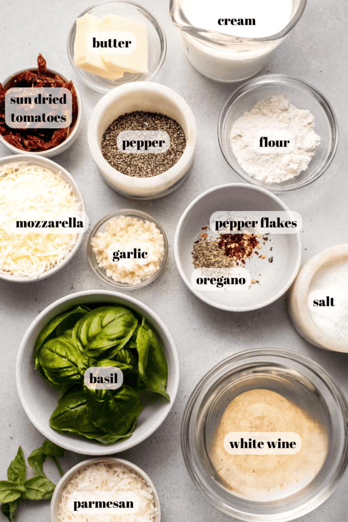 Ingredients for creamy sun dried tomato sauce labeled on counter.