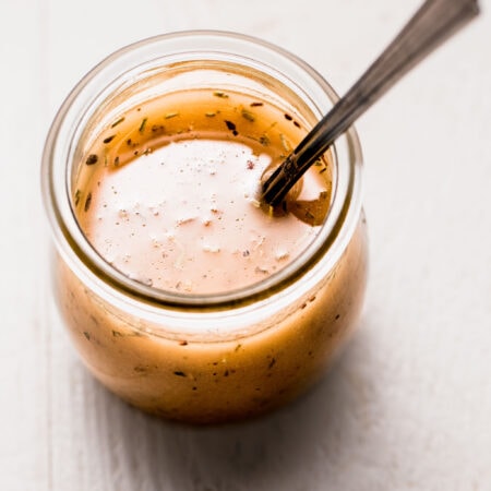 Italian dressing in small jar with spoon.