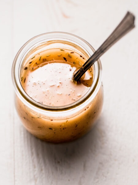 Italian dressing in small jar with spoon.