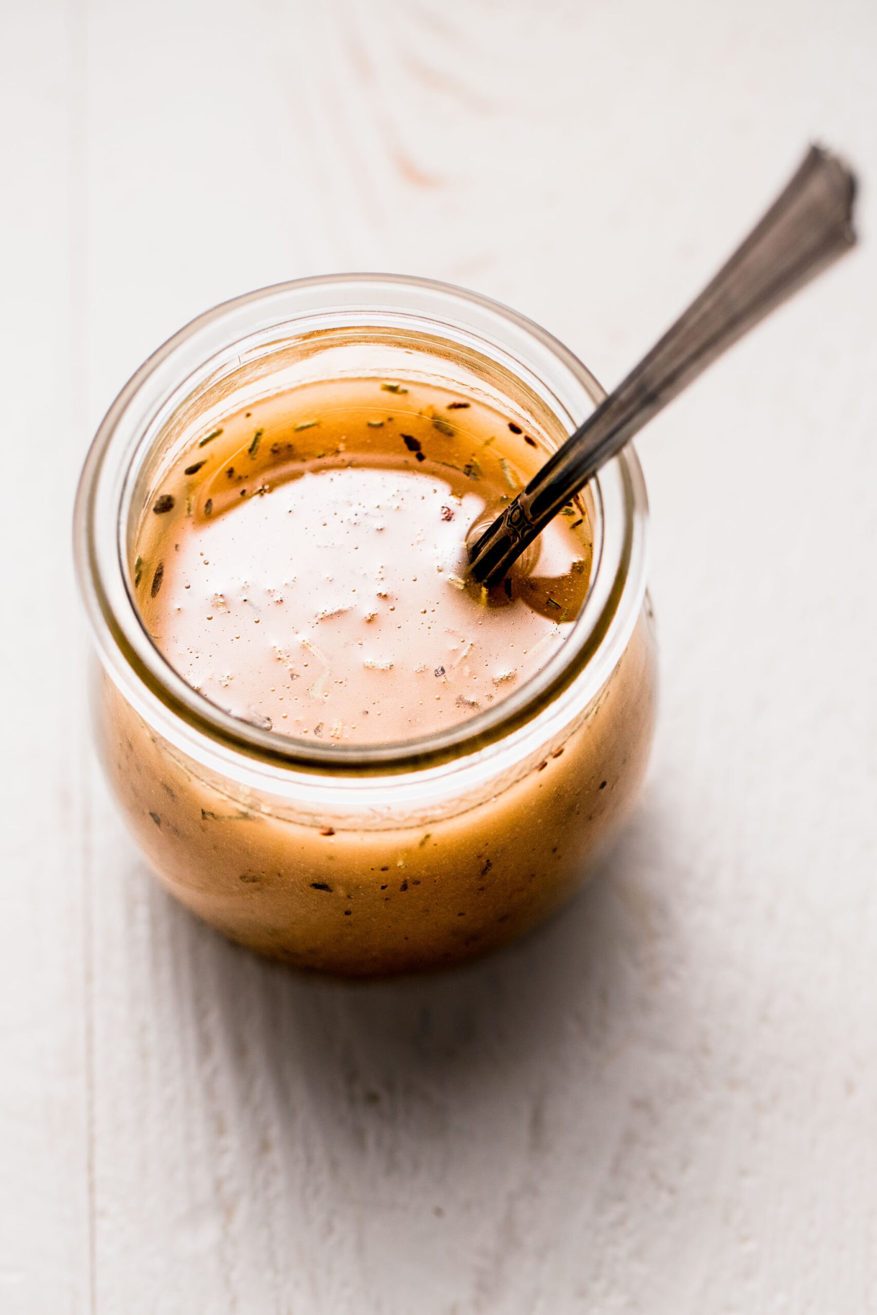 Italian dressing in small jar with spoon.