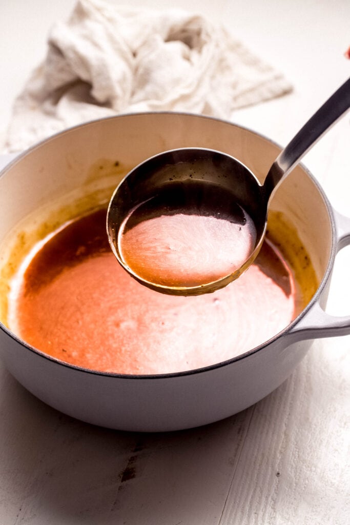 Ladle full of pork gravy.