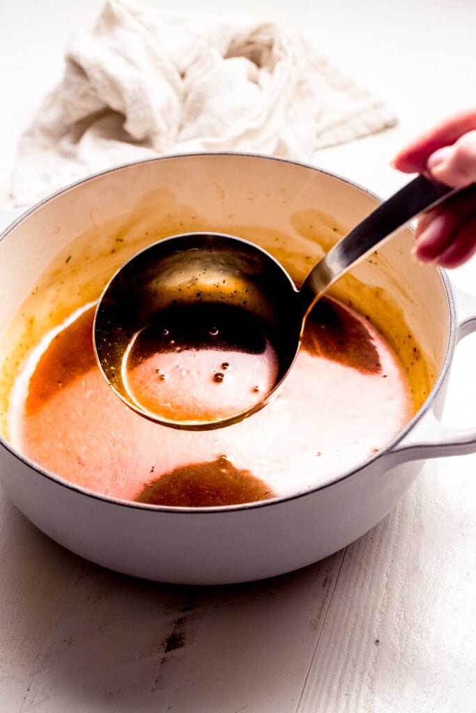 Ladle full of pork gravy.