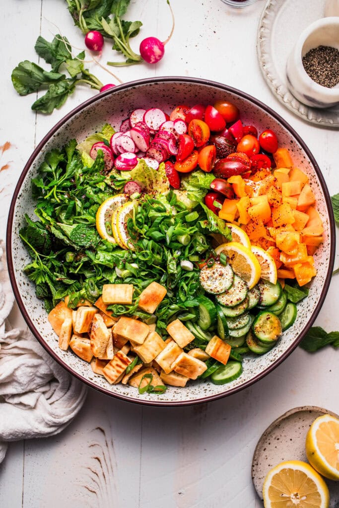 Overhead close up of fattoush salad in bowl before tossing.