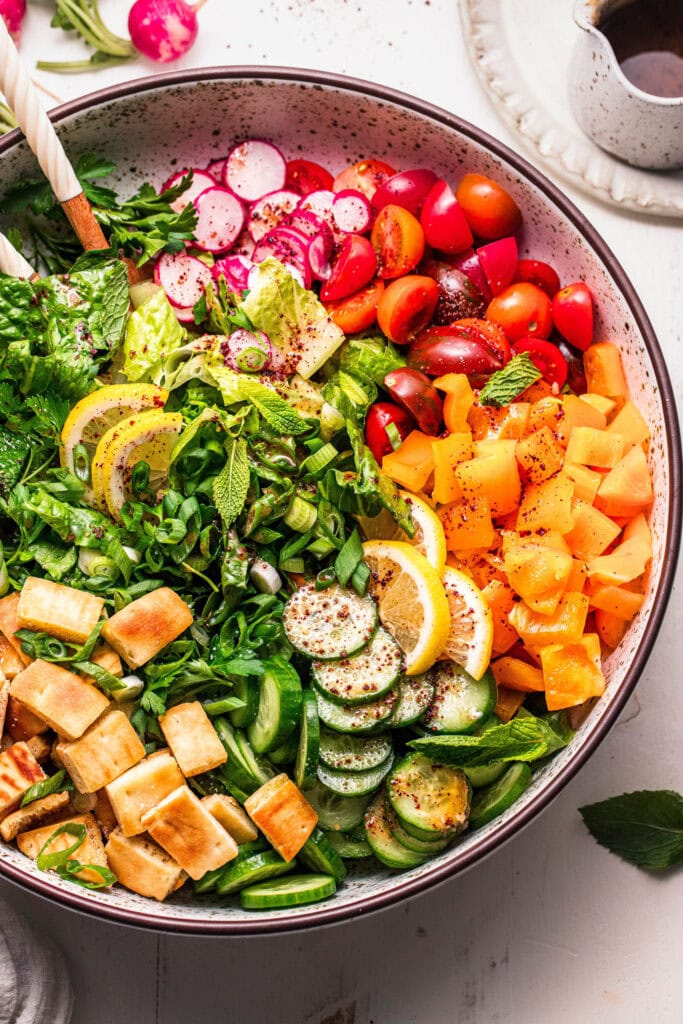 Overhead close up of fattoush salad in bowl before tossing.