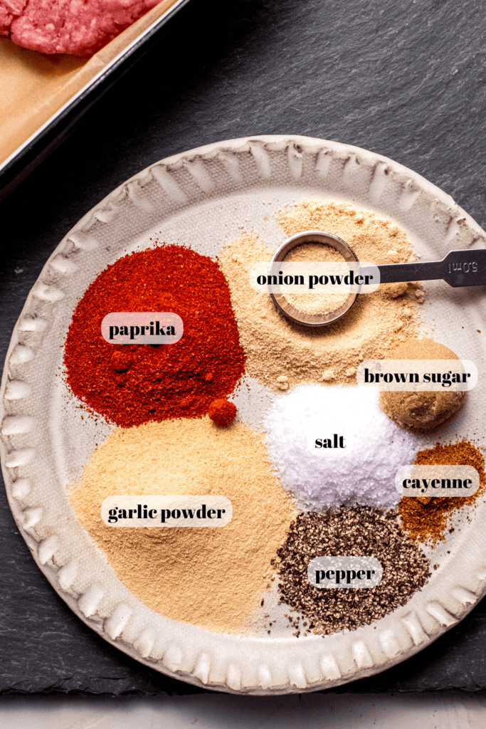 Spices for homemade burger seasoning labeled on plate.