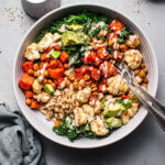 Overhead shot of power bowl next to small container of tahini dressing.