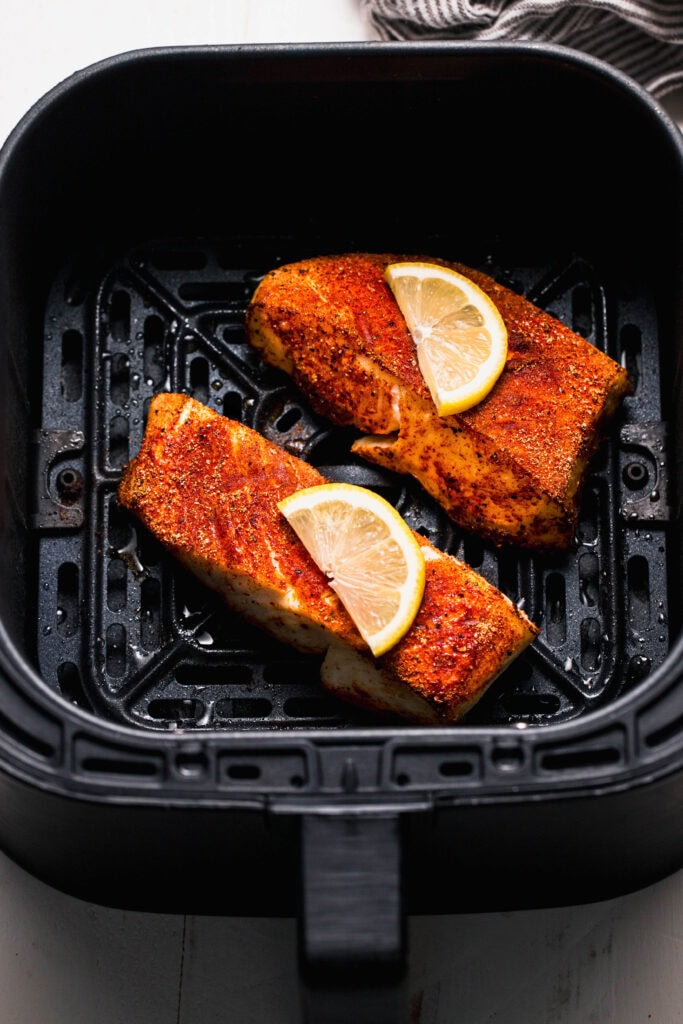 Finished halibut filets cooked in air fryer basket.