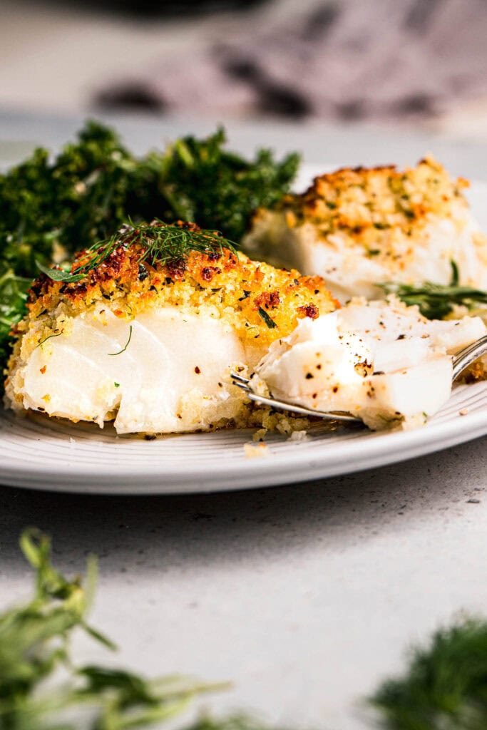 Side view close up of baked cod filet coated in panko. 