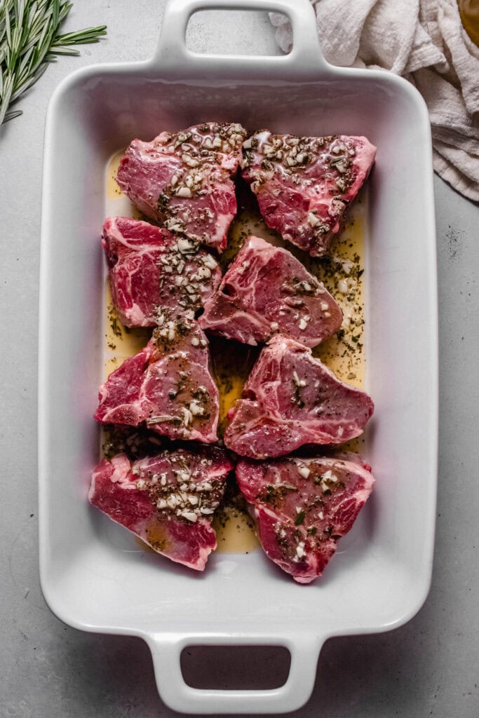 Lamb chops marinating in baking dish. 