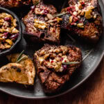 Grilled lamb chops on plate topped with olive relish.