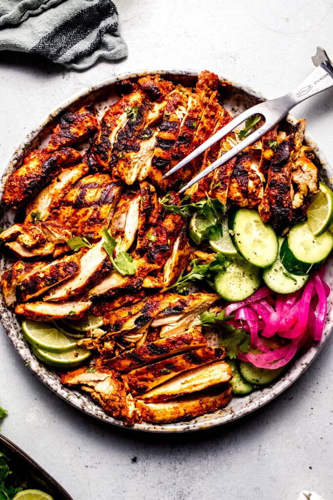 Sliced, grilled achiote chicken on serving plate.