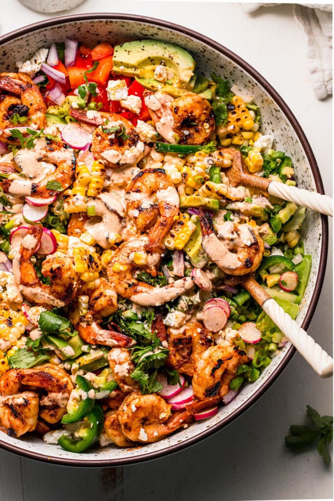 Prepared Street Corn Salad in bowl with serving spoons ready to be served.