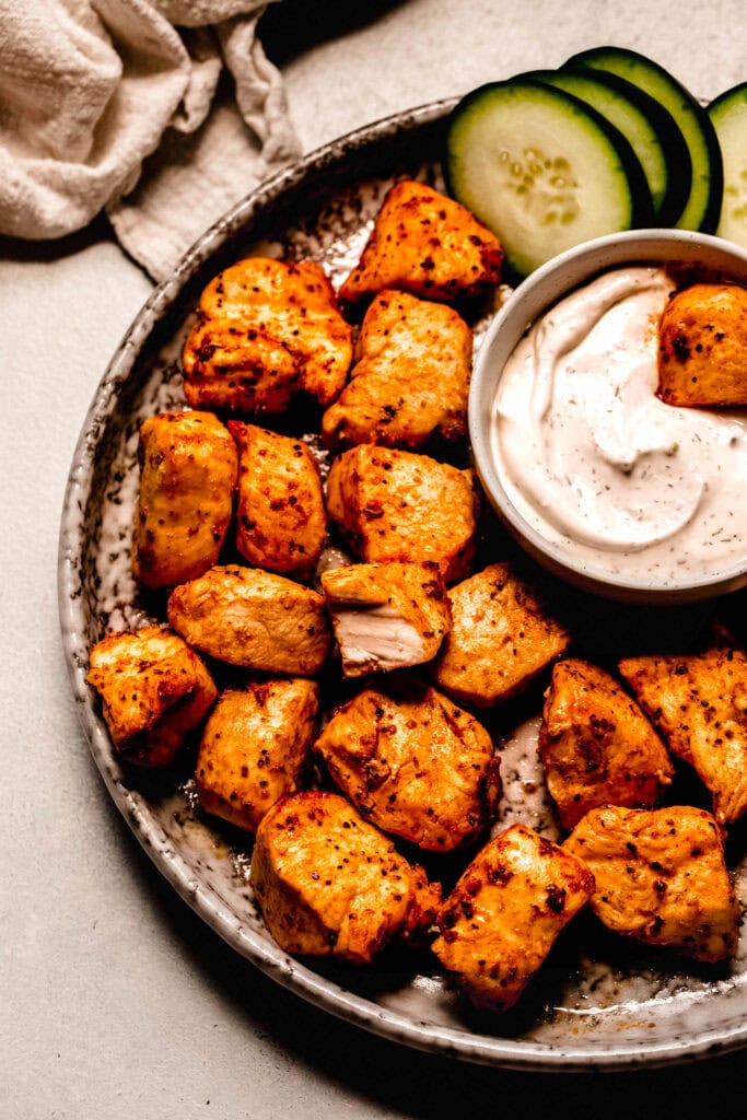 Overhead close up of air fryer chicken bites on plate with dipping sauce.