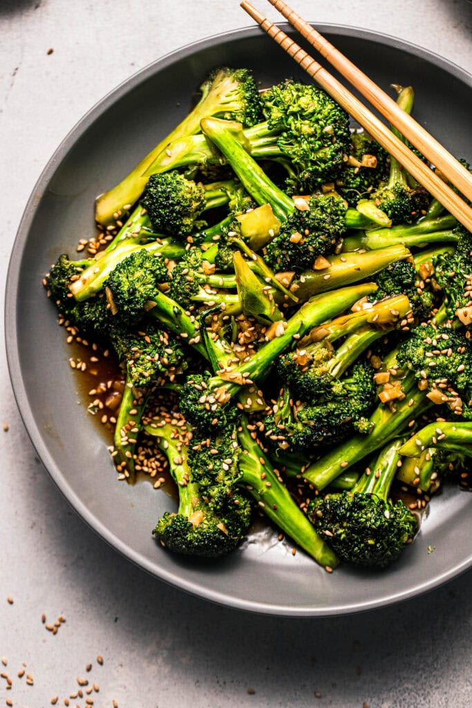 Overhead close up of asian broccoli stir fry in grey serving bowl. 