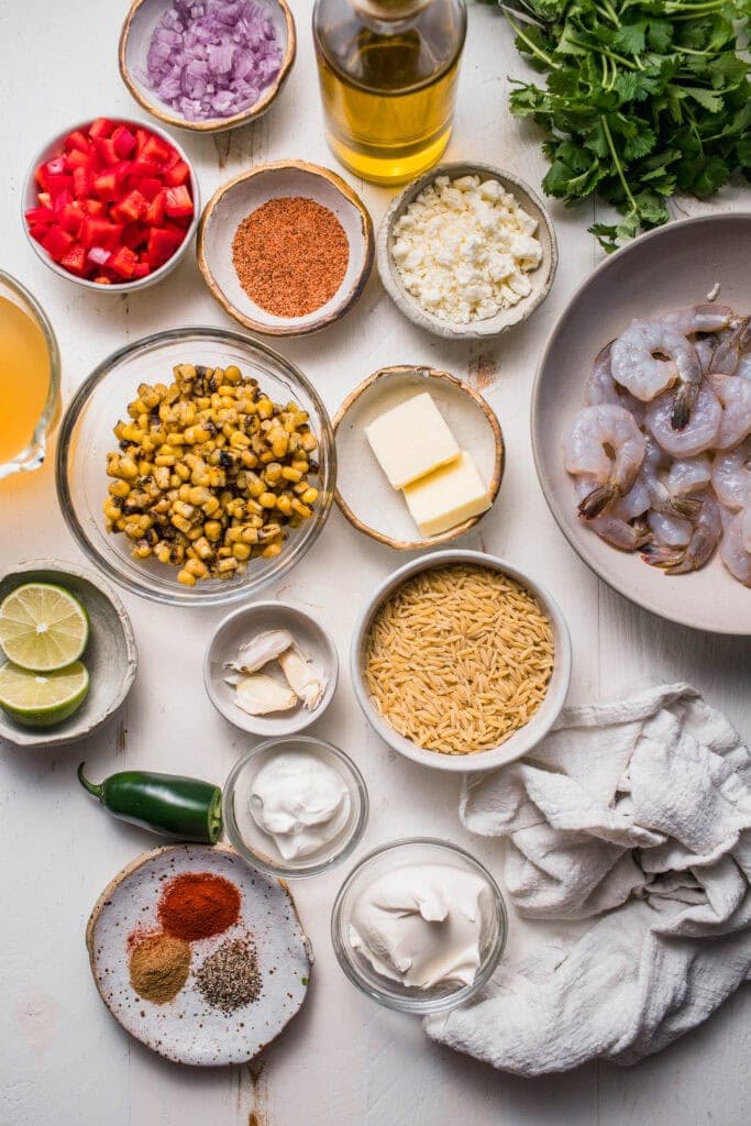 Ingredients for street corn orzo skillet with shrimp on counter.