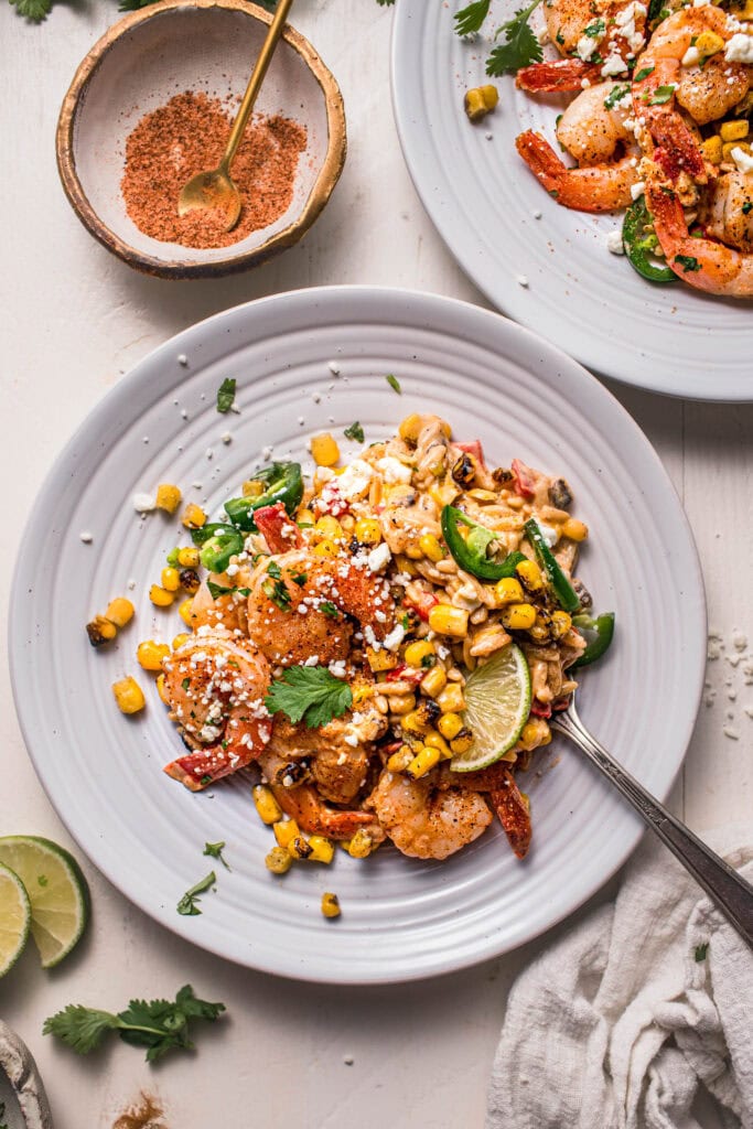 Street corn orzo with shrimp on serving plate.